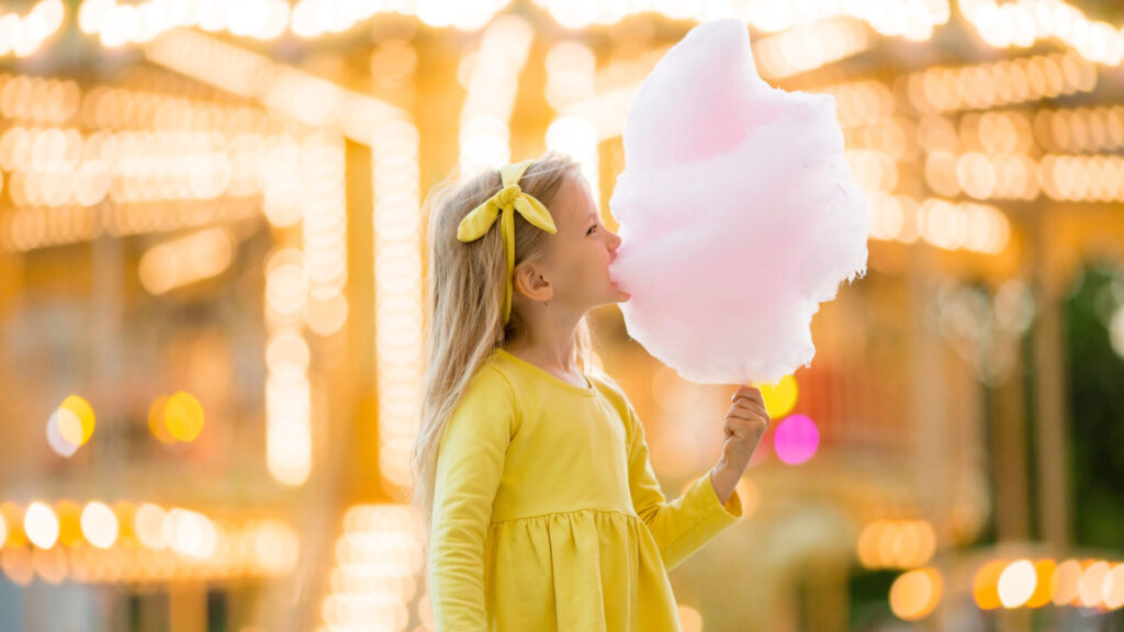 Little,Girl,On,A,Walk,In,An,Amusement,Park,Eating